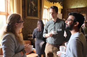 A group of three people chatting over coffee