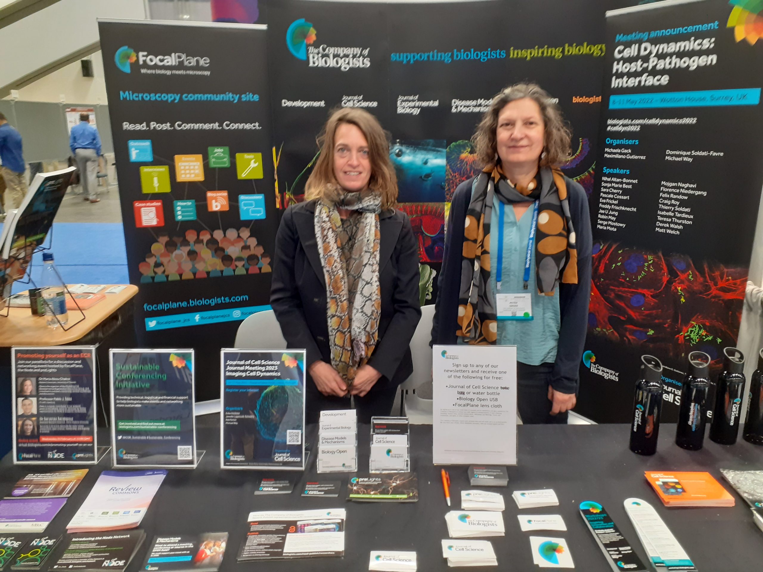 Two people standing at an exhibition booth in a conference hall