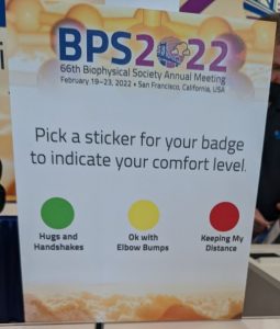 A sign asking attendees to pick a green, yellow or red sticker to indicate their COVID comfort level