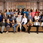 A group photo of all participants of the 2017 workshop, some sat on sofas, others standing behind the sofas
