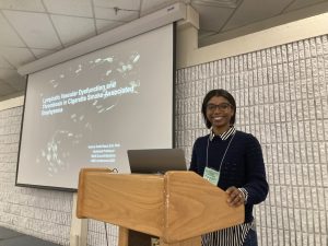 A person standing at a lectern to present her research