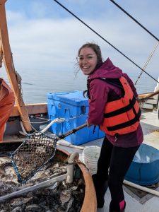 Grace Holmes enjoying a boat ride to collect sea animals used for research purposes.