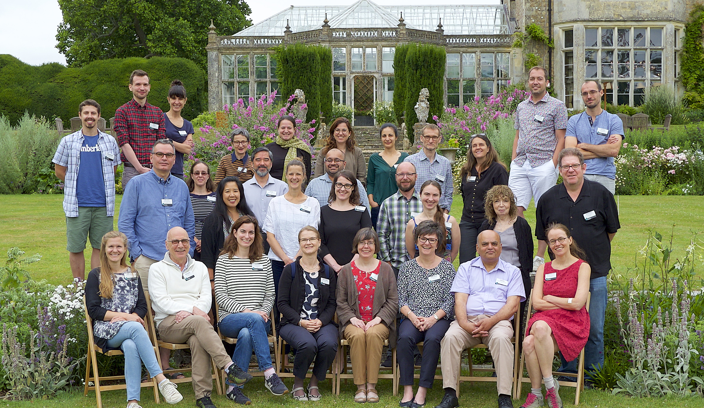 A large group of people posing for a photo in a garden
