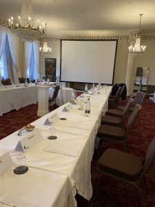 A conference room with a long table and presentation screen