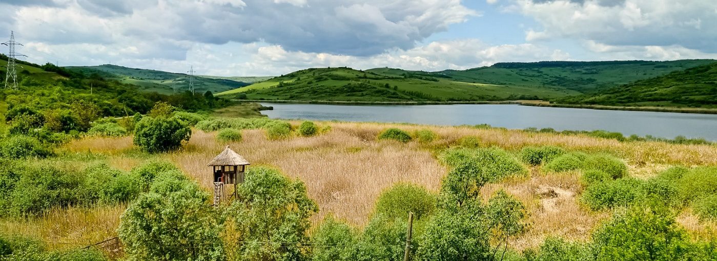 A lake surrounded by hills and countryside. 