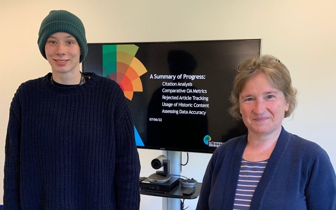 Two people standing in front of a presentation screen