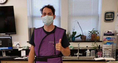 A researcher in the lab wearing a mask and giving the 'thumbs up' sign