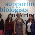Rebekah Tillotson posing with colleagues in front of a wall that says: supporting biologists, inspiring biology