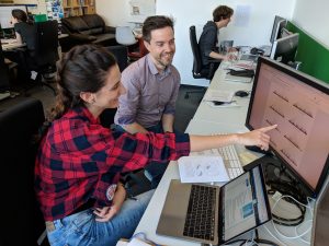 Two researchers looking at data on a computer screen