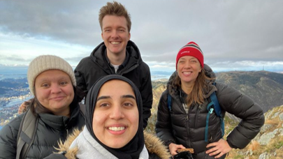 Four people standing on top of a mountain